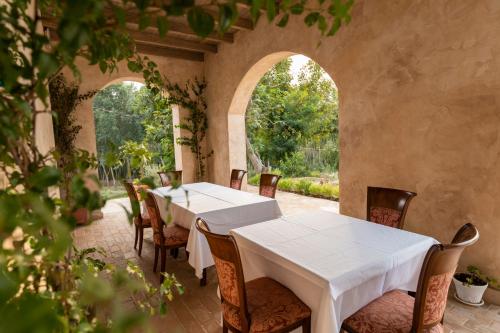 a dining room with white tables and chairs at Agroturizem Gjepali in Shijak