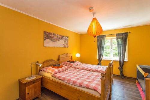 a bedroom with a bed with yellow walls at Hügelhus in Kloster