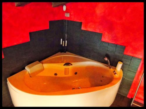 a bath tub in a bathroom with a red wall at Casa Vacanze SoleLuna in Montichiari