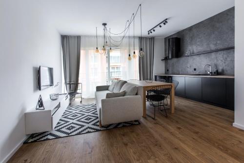 a kitchen and living room with a table and a couch at City Break Gdańsk Rajska 8 Apartamenty in Gdańsk