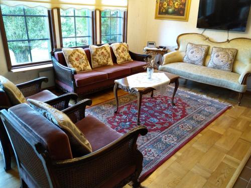 a living room with couches and a table at Villa Lovisa in Loviisa