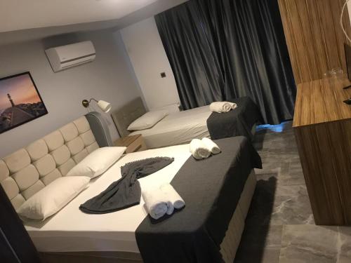 a hotel room with two beds and a couch at FONTANA HOTEL FENER in Çeşme