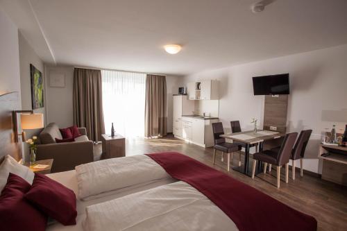 a hotel room with a bed and a dining room at Wein & Bett Weihbrecht in Bretzfeld