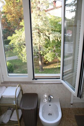 a bathroom with a sink and two large windows at Apartments Villa Sandi in Izola