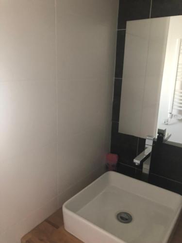 a bathroom with a white sink and a mirror at Oléron in Saint-Denis-dʼOléron