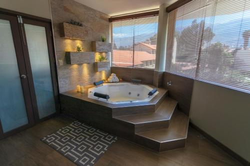 Gran Hotel Cochabamba في كوتشابامبا: حمام مع حوض استحمام و نافذة كبيرة
