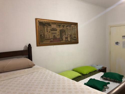a bedroom with two beds and a picture on the wall at Castelo Veraneio in Guarujá