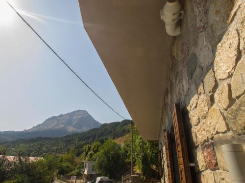 a stone building with a view of a mountain at Liontos Rooms in Pramanta