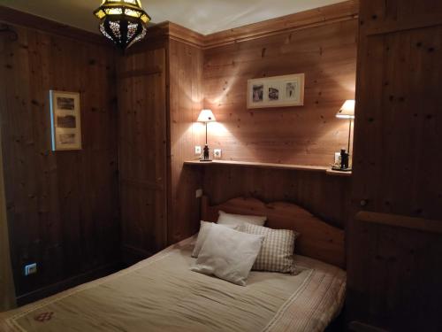 1 dormitorio con 1 cama en una habitación con paredes de madera en Le Pramecou Tignes Val Claret en Tignes