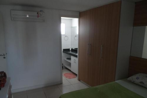 1 dormitorio con armario grande de madera y cocina en Dunna Barcane NATAL, en Natal