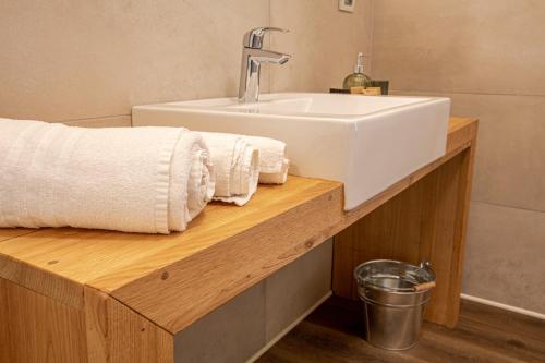 een badkamer met een wastafel en handdoeken op een houten aanrecht bij AGRITURISMO LA CAMPAGNOLA in Montegaldella