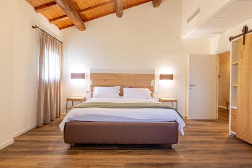 a bedroom with a large bed and wooden floors at AGRITURISMO LA CAMPAGNOLA in Montegaldella