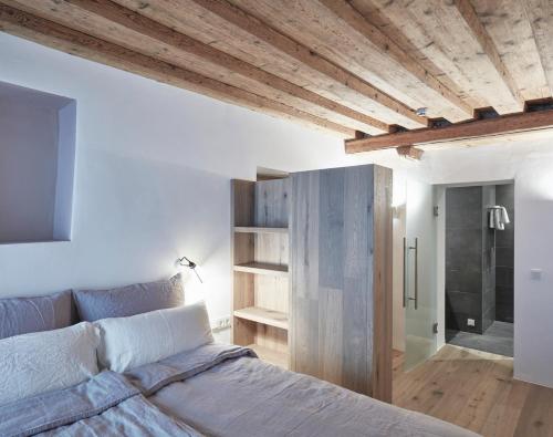 a bedroom with a bed and a wooden ceiling at Faktorei in Innsbruck
