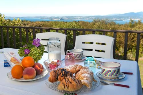 a table with bread and croissants and fruit on it at Casa Fellini in San Zeno di Montagna