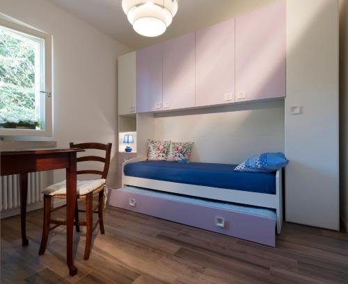 a bedroom with a bed and a desk and a table at Casa Fellini in San Zeno di Montagna