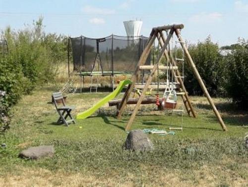 a playground with a slide and a swing set at Maison Tifaloc in Montélimar