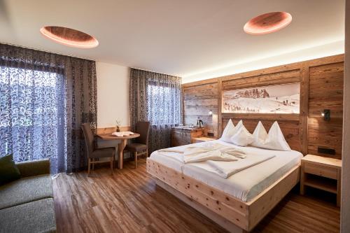 um quarto de hotel com uma cama, uma mesa e uma secretária em Hotel Garnì Savoy em Castelrotto
