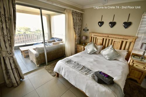 a bedroom with a bed and a view of a balcony at Laguna la Crete 74 & 90 in Margate