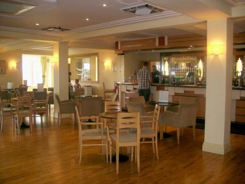 a restaurant with tables and chairs and a bar at Carousel Hotel in Blackpool