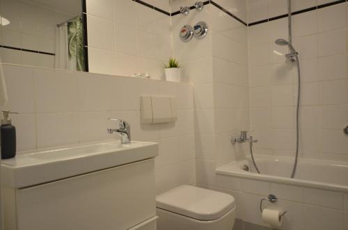 a bathroom with a toilet and a sink and a shower at Fair Apartment MAX 33 in Meerbusch