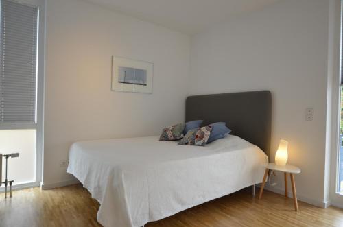 a bedroom with a bed with a white bedspread at Fair Apartment MAX 33 in Meerbusch