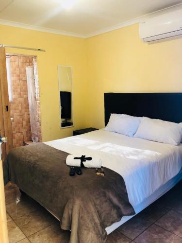 a bedroom with a large bed with two stuffed animals on it at Maite Villa Lodge in Thohoyandou