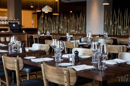 a dining room with wooden tables and chairs with wine glasses at The Study at University City, Study Hotels in Philadelphia