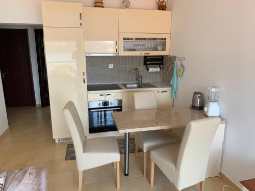 uma pequena cozinha com mesa e cadeiras em Tamaris House Apartment 16 em Herceg Novi