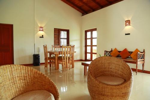 a living room with chairs and a dining room at Villa 61 in Ambepussa