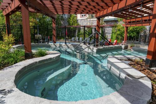 a swimming pool in a backyard with a pergola at Sommet Des Neiges in Mont-Tremblant