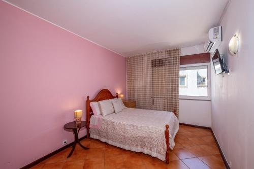 um quarto com uma cama e uma janela em GuestRooms by HOA em Albufeira