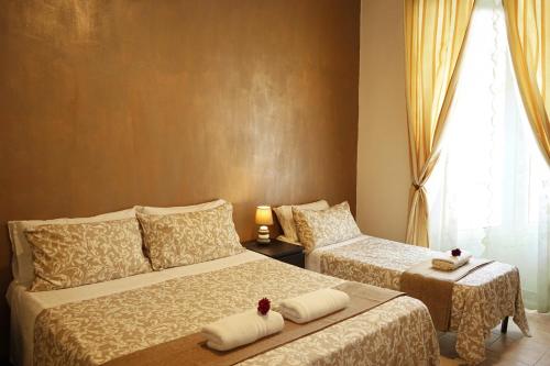 ein Hotelzimmer mit 2 Betten und einem Fenster in der Unterkunft Hosting Flats Guest House in Rom