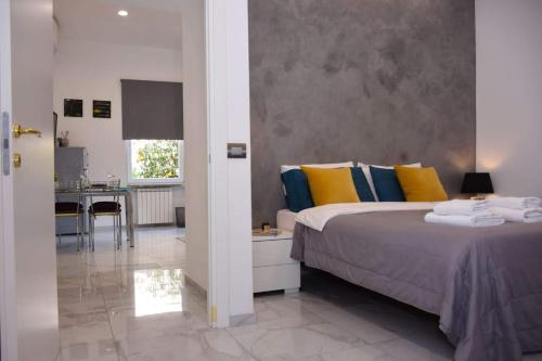 ローマにあるRampa Brancaleone Apartmentのベッドルーム1室(カラフルな枕付きのベッド1台、キッチン付)
