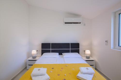 a bedroom with a large bed with towels on it at Dolores Apartments in Petrovac na Moru