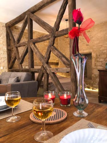 - une table avec des verres à vin et un vase avec une fleur dans l'établissement Les Arcades, à Sarlat-la-Canéda