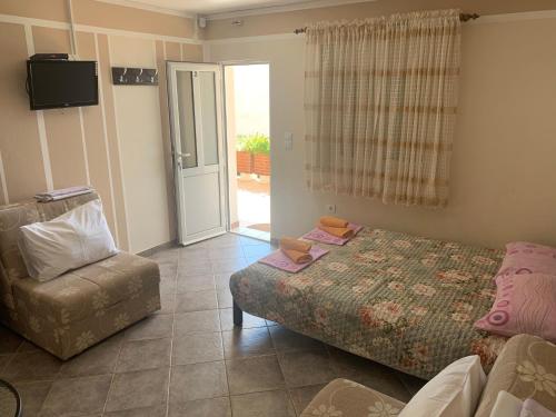 een slaapkamer met een bed, een stoel en een deur bij Apartments in villa Viktoria in Sutomore