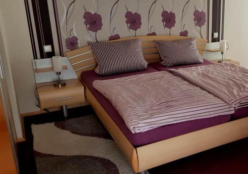 a bedroom with a bed with purple sheets and pillows at Ferienwohnung Weiß Wachtenburg in Wachenheim an der Weinstraße
