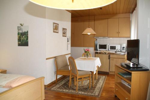 a small kitchen with a table and chairs in a room at Gästehaus Kirchlay in Kröv