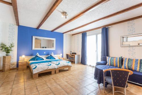 1 dormitorio con paredes azules, 1 cama y 1 sofá en Gasthaus zum Holzwurm en Gransdorf