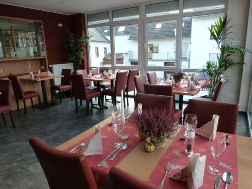 un ristorante con tavoli e sedie con bicchieri da vino di Gasthaus zum Holzwurm a Gransdorf