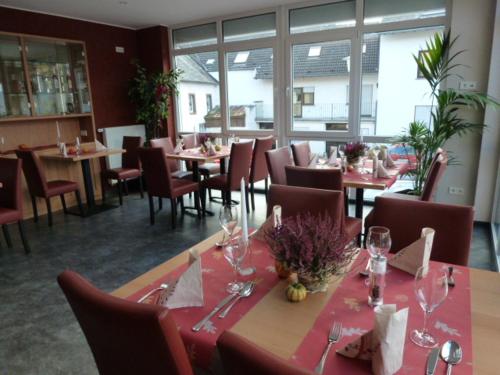 a restaurant with tables and chairs with wine glasses at Gasthaus zum Holzwurm in Gransdorf