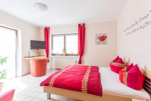 um quarto com uma cama grande e almofadas vermelhas em Gasthaus zum Holzwurm em Gransdorf