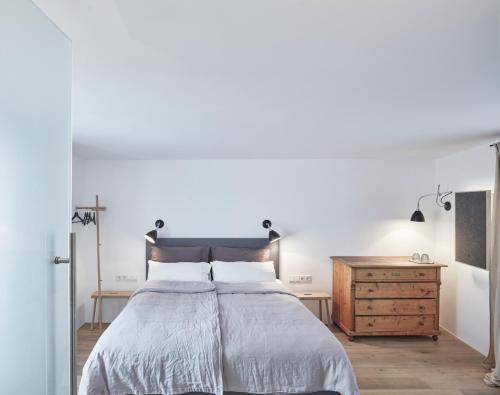 a bedroom with a bed and a wooden dresser at Faktorei in Innsbruck