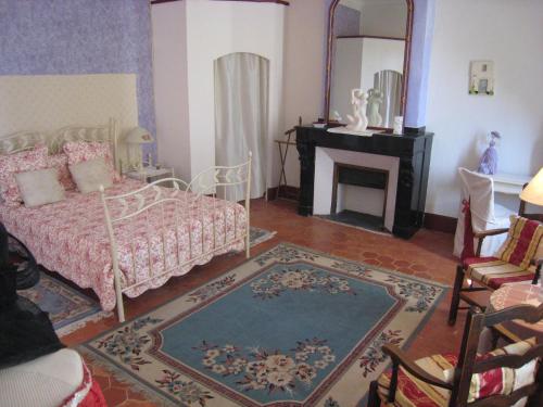 1 dormitorio con cama, chimenea y espejo en Chateau Du Comte, en Saint-Nazaire-dʼAude