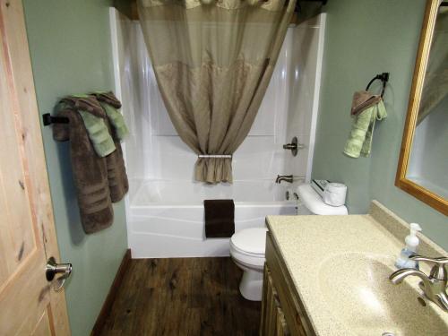 uma casa de banho com uma banheira, um WC e um lavatório. em Freedom Ridge Cabins em Hill City