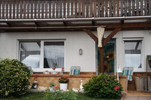 a house with a porch with two chairs and a table at Gästehaus Kirchlay in Kröv