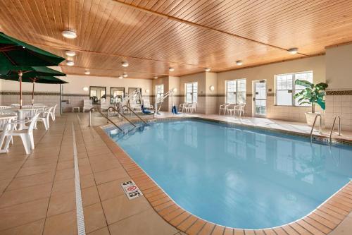 einen Pool in einem Hotel mit Tischen und Stühlen in der Unterkunft Country Inn & Suites by Radisson, Red Wing, MN in Red Wing