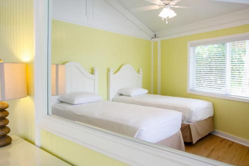 a bedroom with two beds and a mirror at Topsider Resort by Capital Vacations in Lower Matecumbe Beach
