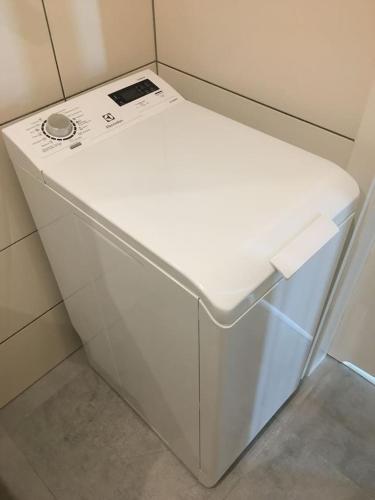 a small white refrigerator in a corner of a room at Studio Fibra Lungo in Rybnik