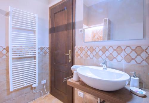 モンカルヴォにあるAgriturismo Cascina Olivettaのバスルーム(白いシンク、木製のドア付)
